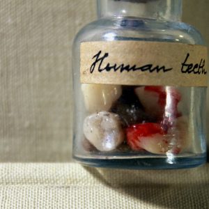 Human teeth in a vintage vial