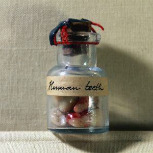 Human teeth in a vintage vial